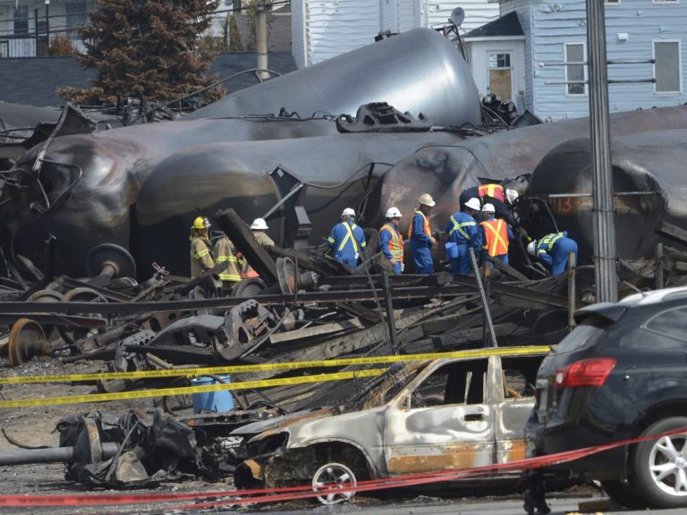 FILE - In this July 6, 2013 file photo, emergency workers examine the aftermath of a train derailment and fire in Lac-Megantic, Quebec, Canada. Forty-seven people were killed. U.S. federal regulators are further tightening testing requirements for companies that transport oil by rail after a spate of explosions caused by crude train derailments in the U.S. and Canada. The action on Thursday, March 6, 2014 from the U.S. Department of Transportation builds on a Feb. 25 order that targeted oil shipments for more stringent testing. (AP Photo/Ryan Remiorz, File, Pool)