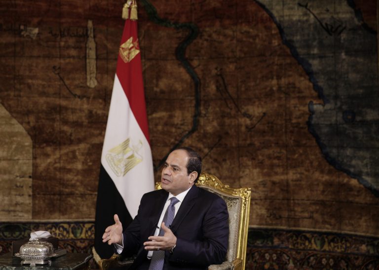 Egyptian President Abdel-Fattah el-Sissi speaks to The Associated Press during an interview at the presidential palace in Cairo, Saturday, Sept. 20, 2014. In the background is a 1930s era carpet depicting a map of Egypt. In his first interview with foreign media since taking office in June, el-Sissi has told AP he is prepared to give whatever support is needed in the fight against the Islamic State group but says military action is not the only answer. (AP Photo/Maya Alleruzzo)