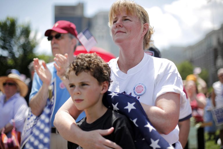   Deb Mirenda of Coatesville, Pa. and her son Vincent, 9, listen to a speaker, during a protest against the Obama administration mandate that employers provide workers birth control coverage, at Independence Mall, Friday, June 8, 2012, in Philadelphia. The event was organized by Stand Up For Religious Freedom. (AP Photo/Matt Rourke)  