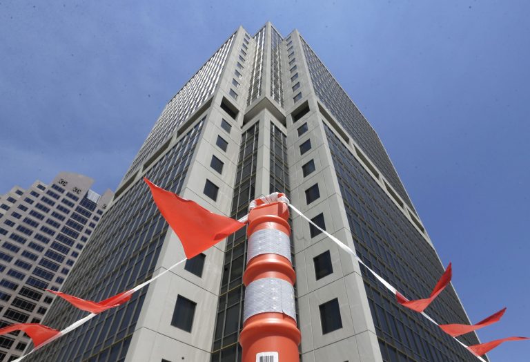 In this Wednesday, July 2, 2014 photo, warning flags hang on the parking garage of the State Board of Equalization building in Sacramento, Calif. The building, which houses the headquarters of the state agency that administers taxes and fees, has been plagued with problems including panes of glass popping out and crashing to the sidewalk, elevators stalling and corroding pipes damaging the buildings's water system, since it was opened in 1993.(AP Photo/Rich Pedroncelli)