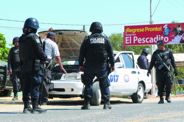 State police check a taxi at a roadblock due to stepped up security after masked armed men broke into a beach home, raping six Spanish tourists who had rented the house in Acapulco, Mexico, Tuesday Feb. 5, 2013. According to the mayor of Acapulco, five masked men burst into a house the Spaniards had rented on the outskirts of Acapulco, in a low-key area near the beach, and held a group of six Spanish men and one Mexican woman at gunpoint, while they raped the Spanish women before dawn on Monday. (AP Photo/Bernandino Hernandez)