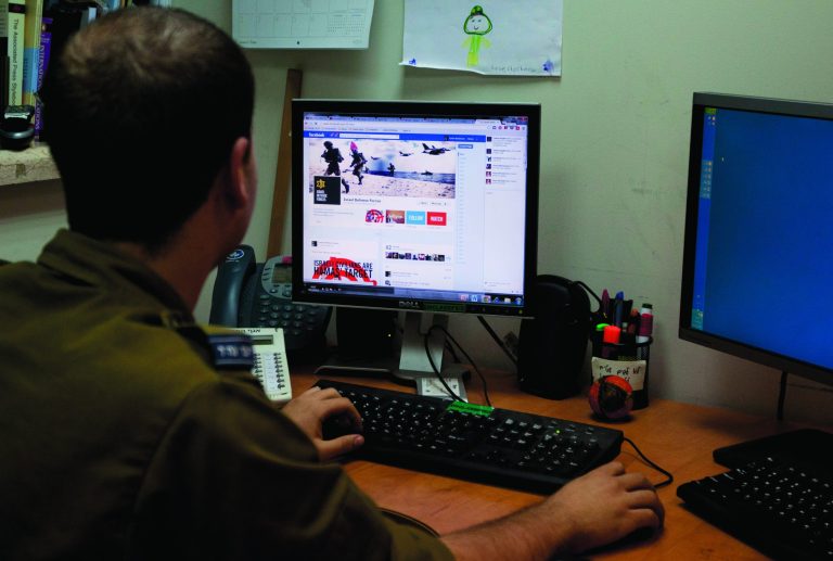 An Israeli soldier looks at the Facebook page of the IDF, at the IDF spokesperson office in Jerusalem, Thursday, Nov. 15, 2012. The hostilities between Israel and Hamas have found a new battleground: social media. The Israeli Defense Force and Hamas militants have exchanged fiery tweets throughout the fighting in a separate war to influence public opinion. (AP Photo/Sebastian Scheiner)