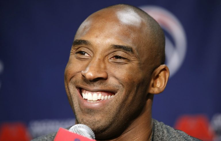 Los Angeles Lakers guard Kobe Bryant smiles during a media availability before an NBA basketball game against the Washington Wizards Tuesday, Nov. 26, 2013, in Washington. The Lakers signed Bryant to a two-year contract extension Monday, securing the fourth-leading scorer in NBA history into his 20th season with the franchise. (AP Photo/Alex Brandon)