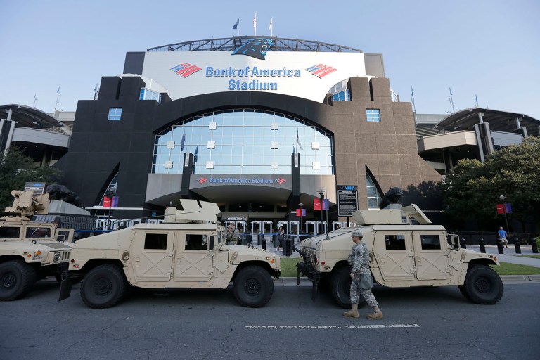 North Carolina National Guard vehicles are parked in front of an entrance to Bank of America Stadium before a game between the Carolina Panthers and the Minnesota Vikings in Charlotte, N.C. (AP Photo/Chuck Burton)