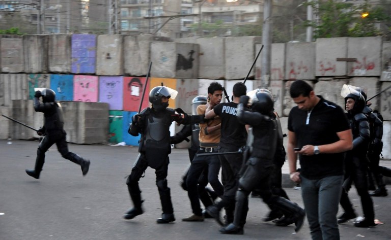 Egyptian riot police detain a protester during clashes outside the presidential palace in Cairo, Friday, April 26, 2013. Dozens of mostly masked protesters hurled stones and firebombs in clashes with riot police at Egypt's presidential palace in a Cairo suburb. Protests have become a weekly routine in Egypt, as the country has plunged in turmoil during most of the past two years since 2011 uprising which ousted longtime president Hosni Mubarak out of power. (AP Photo/Hussein Tallal)