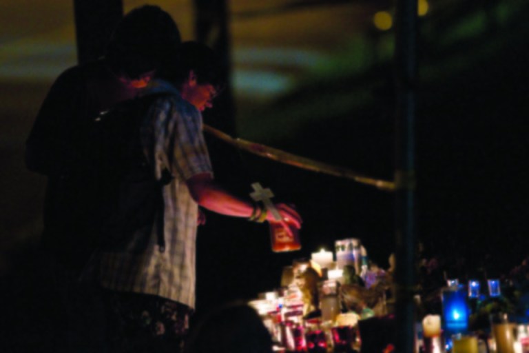 Local residents light candles at a memorial while rescue workers wait to access the wreckage of the Algo Centre Mall in Elliot Lake, Ontario, Canada on Wednesday, June 27, 2012. Officials recovered a body Wednesday after spending the night dismantling a partially collapsed Ontario mall in a renewed rescue effort after angry residents had shouted down fears that the unstable structure made the work too risky to continue. Part of the roof collapsed last Saturday afternoon. At least 22 people had minor injuries. (AP Photo/The Canadian Press, Chris Young)