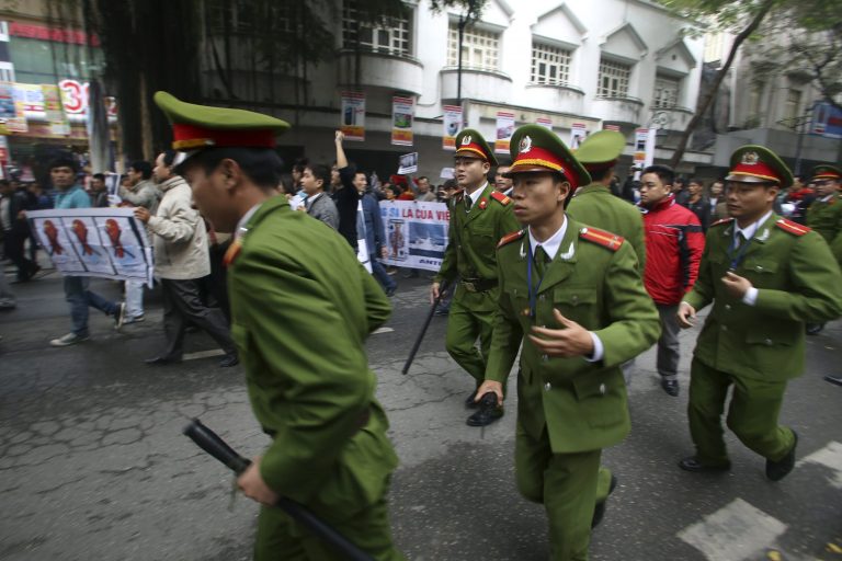   Vietnamese policemen run to block protesters as they march during a demonstration demanding China to stay out of their waters following China's increased activities around the Spratly Islands and other disputed areas, in Hanoi, Vietnam on Sunday, Dec. 9, 2012. Vietnamese police broke up anti-China protests in two cities on Sunday and made about 20 arrests in the first such demonstrations since tensions between the communist neighbors flared anew over rival claims to the oil and gas-rich South China Sea. (AP Photo/Na Son Nguyen)  