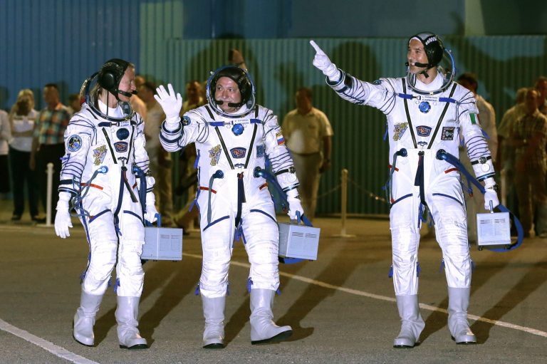 U.S. astronaut Karen Nyberg, left, Russian cosmonaut Fyodor Yurchikhin, center, and European Space Agency astronaut Luca Parmitano crew members of the mission to the International Space Station, ISS, gesture as walk prior the launch of their Soyuz-FG rocket at the Russian leased Baikonur cosmodrome, Kazakhstan, Tuesday, May 28, 2013. (AP Photo/Mikhail Metzel)