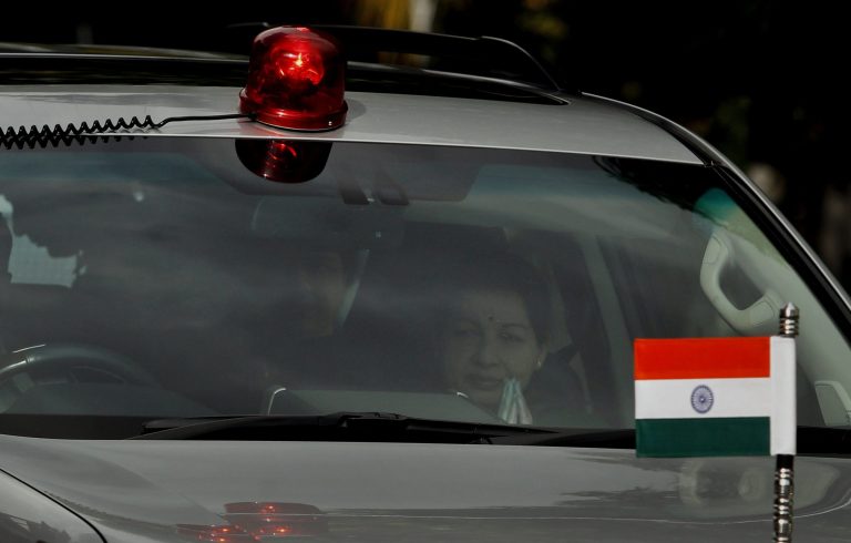 Chief Minister of Tamil Nadu state Jayaram Jayalalitha, right, is seen through the mirror of a car as she comes out of her house in Chennai, India, Saturday, Sep. 27, 2014. A court in southern India has found the top elected official of Tamil Nadu state guilty of corruption in a case filed 18 years ago. Jayalalitha will have to step down as the state chief minister after the court on Saturday found her guilty of possessing wealth disproportionate to her known sources of income. (AP Photo/Arun Sankar K.)