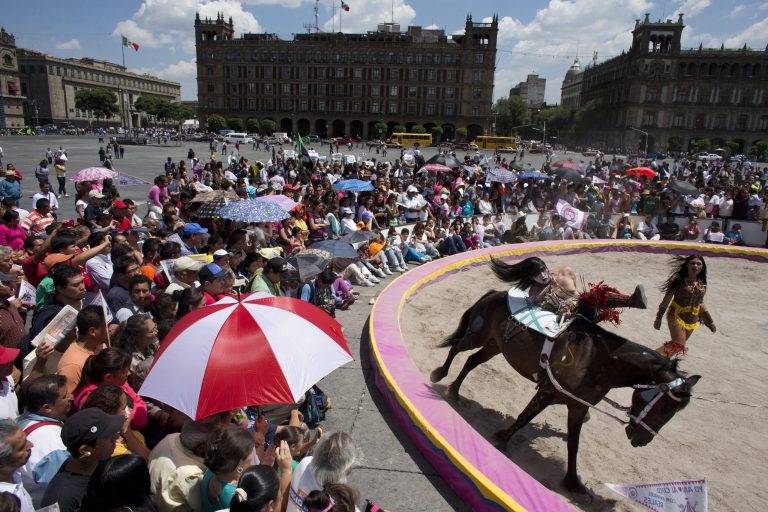 A circus performer dressed in native American garb leaps on and off a running horse, during a free public show to protest Mexico City's ban on circus animals in Mexico City's main square, the Zocalo, Tuesday, July 22, 2014. Mexico's 