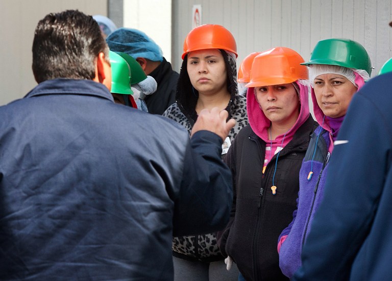 Hector Calderon, foreground, a manager for the Crunch Pak sliced apple company, speaks to workers demonstrating outside the production warehouse in Cashmere, Wash., on Friday, May 9, 2014. They walked away from work in a protest because a number of them may be taken off the job due to an U.S. Immigration and Customs Enforcement audit in August 2013. (AP Photo/The Wenatchee World, Don Seabrook)