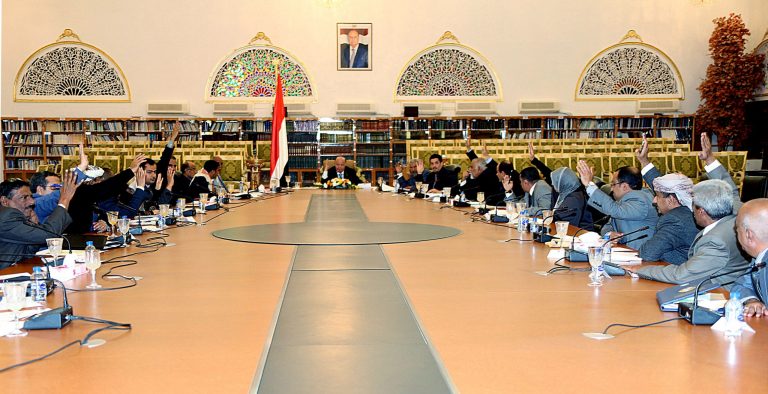 In this photo provided by Yemen's Defense Ministry, Yemeni President Abed Rabbo Mansour Hadi, center, and a presidential panel raise their hands to vote on the final approval on transforming Yemen into a federal state of six regions in Sanaa Yemen, Monday, Feb. 10, 2014. A key Yemeni panel tasked with devising a new system to address the local grievances that have fed the impoverished Arabian Peninsula nation's instability agreed Monday to transform the country into a state of six regions. (AP Photo/Yemen's Defense Ministry)