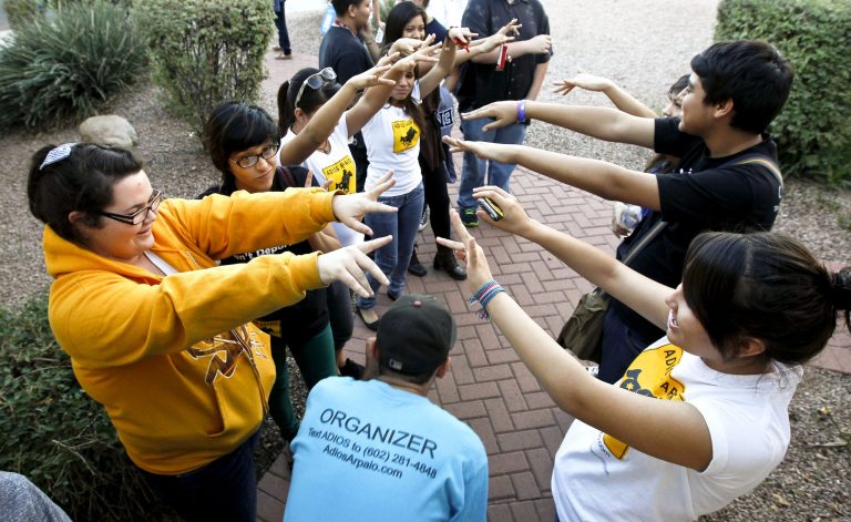 Members of Promise Arizona in Action volunteers cheer as they as they leave their headquarters to go canvass a neighborhood for voter registration Thursday, Oct. 25, 2012, in Phoenix.(AP Photo/Ross D. Franklin)