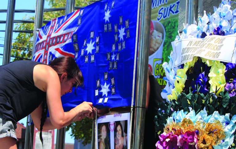 A relative of the 2002 Bali bombings attaches the Australian flag to the Bali memorial monument as she pays her respect to victims who were killed in the bombings in Kuta, Bali, Indonesia, Thursday, Oct. 11, 2012. Australian Prime Minister Julia Gillard is scheduled to attend a ceremony commemorating 10 years from the attacks on two nightclubs that killed 202 people, mostly foreign tourists. (AP Photo/Firdia Lisnawati)