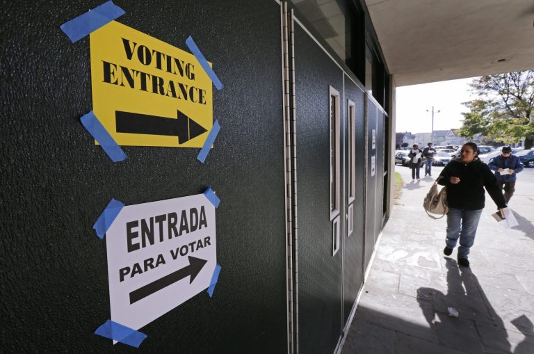 With bilingual signs on the door, voters walk into Bassick High School to cast their ballot in Bridgeport, Conn., Tuesday, Nov. 6, 2012.(AP Photo/Charles Krupa)