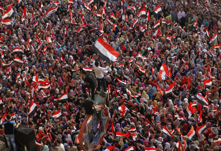 Opponents of Egypt's Islamist President Mohammed Morsi shout slogans and wave national flags in Tahrir Square in Cairo, Egypt, July 2. (Amr Nabil/AP)