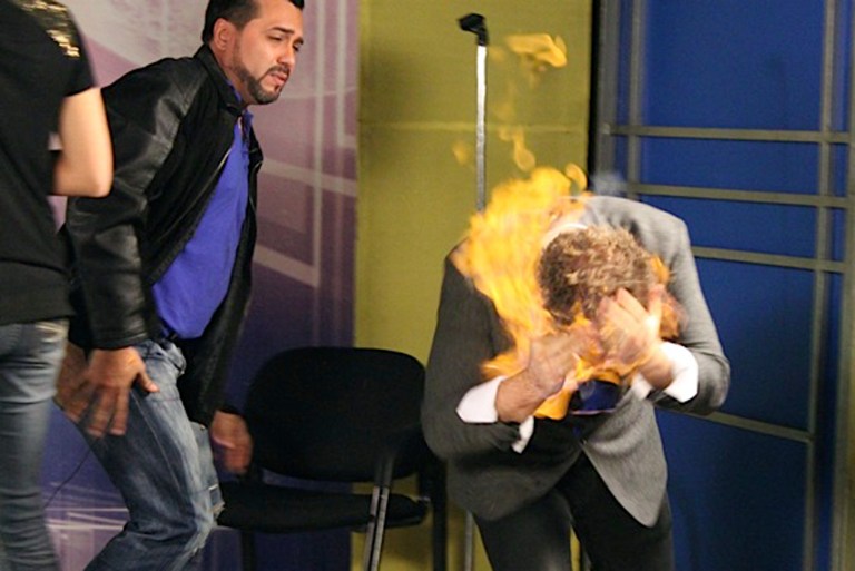   In this picture released by American magician Wayne Houchin, Dominican TV presenter Franklin Barazarte, left, watches as Houchin's head burns while taping 