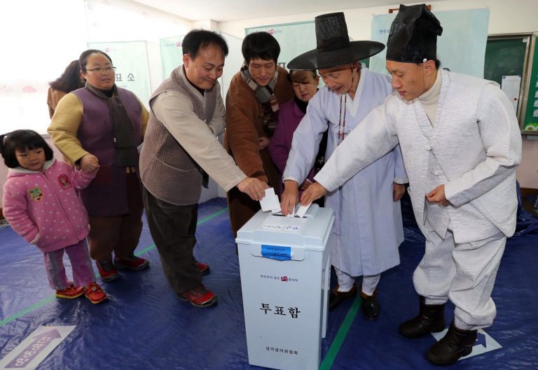   South Korean Confucian scholars, wearing traditional attire, and their family members pose for photographers as they cast their ballots in presidential election at a polling station in Nonsan, South Korea, Wednesday, Dec. 19, 2012. South Koreans bundled-up in thick mufflers and parkas braved frigid weather Wednesday to choose between the liberal son of North Korean refugees and the conservative daughter of a late dictator. (AP Photo/ Yonhap, Yang Yeong-seok) KOREA OUT  