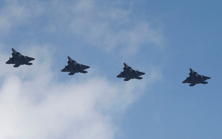 Four U.S. F-22 stealth fighters fly over Osan Air Base in Pyeongtaek, South Korea, Wednesday, Feb. 17, 2016. (AP Photo/Lee Jin-man)