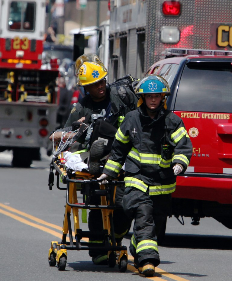 Rescue personnel evacuate an injured person from the scene of a building collapse in downtown Philadelphia Wednesday, June 5, 2013. A four-story building being demolished collapsed Wednesday on the edge of downtown, injuring 12 people and trapping two others, the fire commissioner said. (AP Photo/Jacqueline Larma)