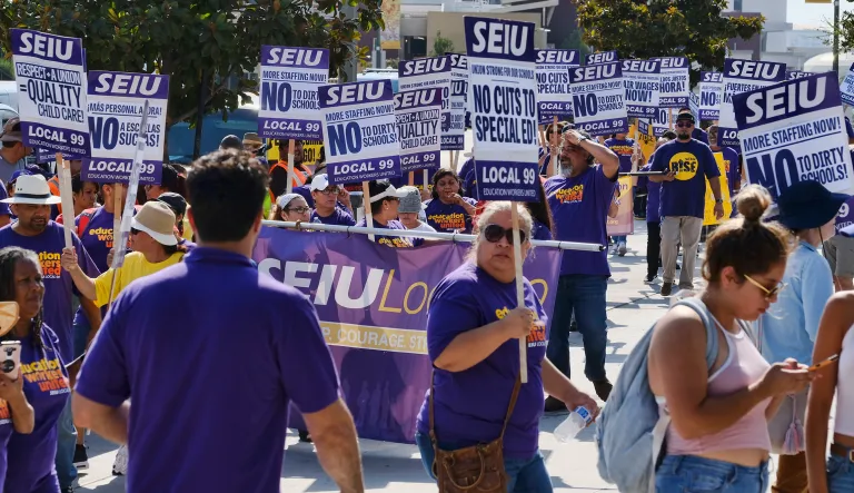 In this photo from Sept. 4, 2017, members of the Service Employees International Union, SEIU, gather for a Labor Day rally in downtown Los Angeles. The SEIU works with traditional unions, but it also partners with worker centers that operate just outside of federal labor law, allowing them to recruit and organize in a manner that traditional union organizers cannot. (AP Photo/Richard Vogel)