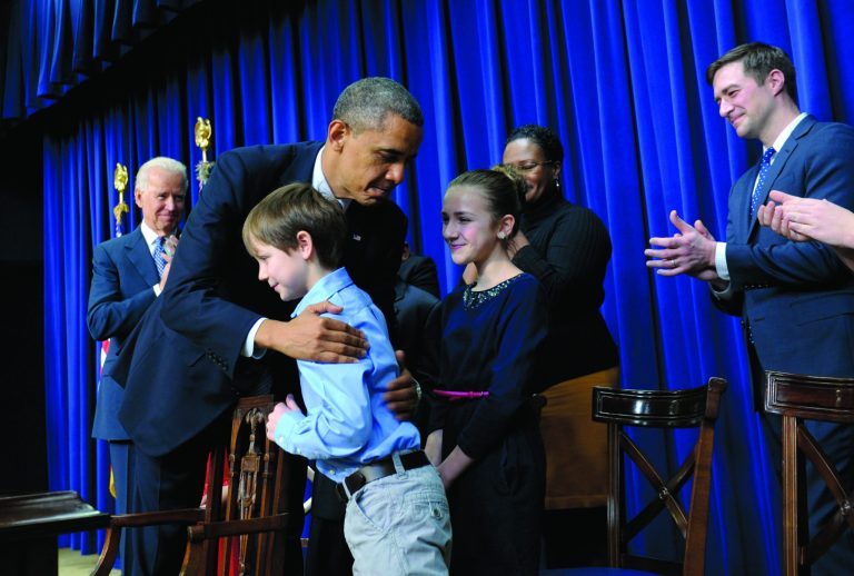 President Barack Obama, accompanied by Vice President Joe Biden, left, hugs eight-year-old letter writer Grant Fritz during a news conference on proposals to reduce gun violence, Wednesday, Jan. 16, 2013, in the South Court Auditorium at the White House in Washington. Obama and Biden were joined by law enforcement officials, lawmakers and children who wrote the president about gun violence following the shooting at an elementary school in Newtown, Conn., last month. (AP Photo/Susan Walsh)