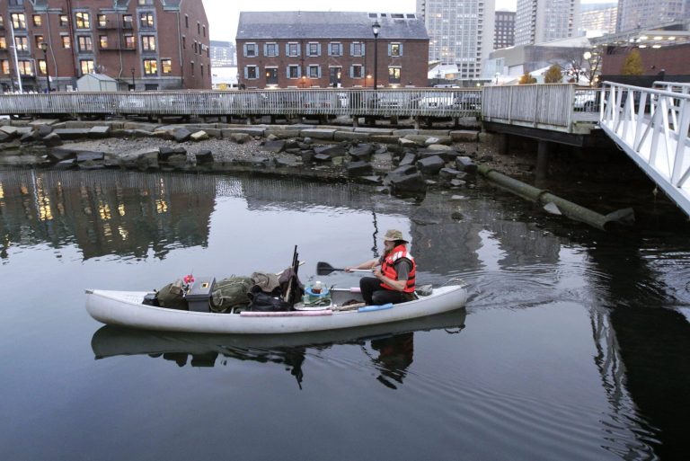   Michael Richard Smith pilots his canoe in Boston Harbor, in Boston, Tuesday, Dec. 4, 2012. The 49-year-old Maine native said Tuesday that heâs been paddling the waters of metro Boston since at least late summer with all of his possessions aboard a 14-foot, 40-year-old aluminum canoe that he patches with duct tape when necessary. (AP Photo/Steven Senne)  