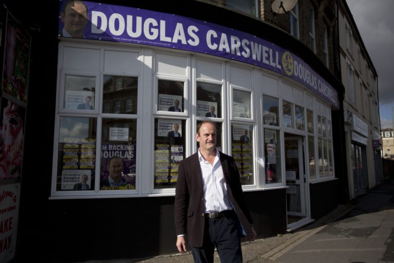 In this picture taken on Tuesday, Oct. 7, 2014, Douglas Carswell, the UK Independence Party (UKIP) candidate for the Clacton by-election, poses for photographs outside his campaign offices in Clacton-on-Sea, England. The U.K. Independence Party is finding a warm welcome in this seaside town for its promise to curb immigration and leave the European Union. But the invasion washing up here isn't from across the water _ it's an army of UKIP supporters from around the country, flocking to Clacton-on-Sea to help the party make an electoral breakthrough that could change the face of British politics. (AP Photo/Matt Dunham)