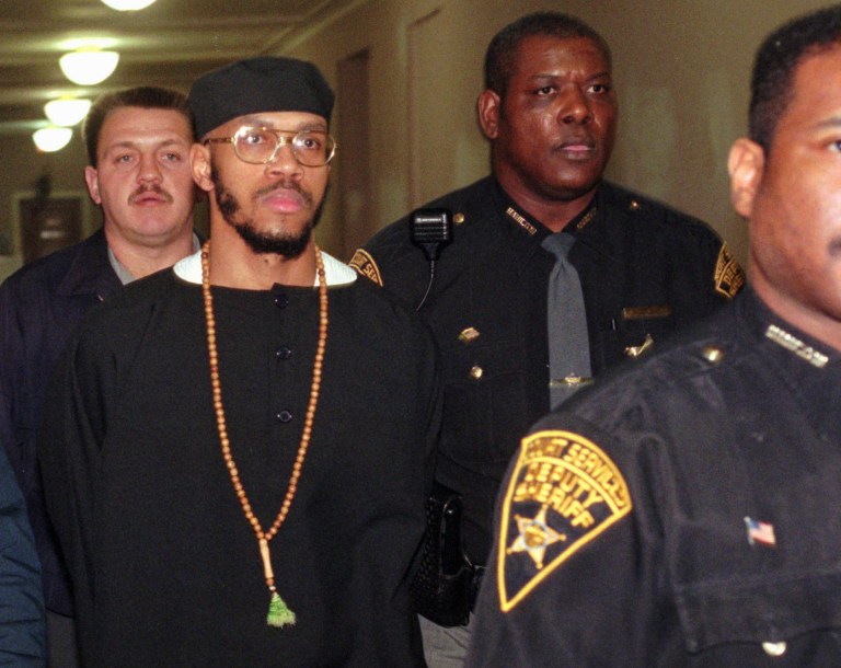 FILE - This Tuesday, Jan. 16, 1996 file photo shows Carlos Sanders, with cap, under heavy guard as he is led to court in Cincinnati, where jury selection began on his aggravated murder, kidnapping, and assault trial. Sanders is the alleged ringleader in the 1993 Lucasville prison riot. In the 20 years since the nation's longest deadly prison riot broke out in Lucasville, no interviews have been granted with the five men sentenced to death in the killing of a guard. Yet time has brought new evidence and insights that will dominate events marking the 20th anniversary of the 11-day siege of April 1993. (AP Photo/Al Behrman, File)