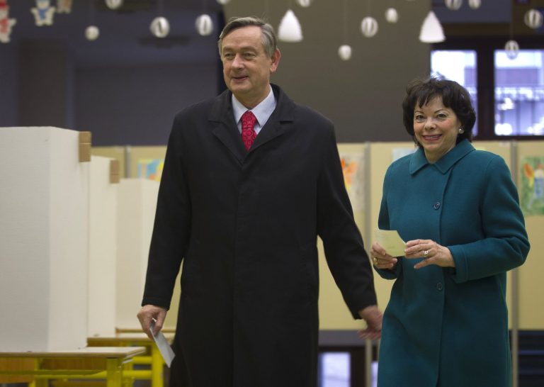   Slovenia's incumbent President Danilo Turk, left, with his spouse Barbara Miklic prepares to cast his ballot a polling station in Ljubljana, Slovenia, Sunday, Dec. 2, 2012. Small, crisis-hit EU member Slovenia is choosing a president in an atmosphere of uncertainty and growing discontent with cost-cutting measures designed to avoid an international bailout. (AP Photo/Darko Bandic)  
