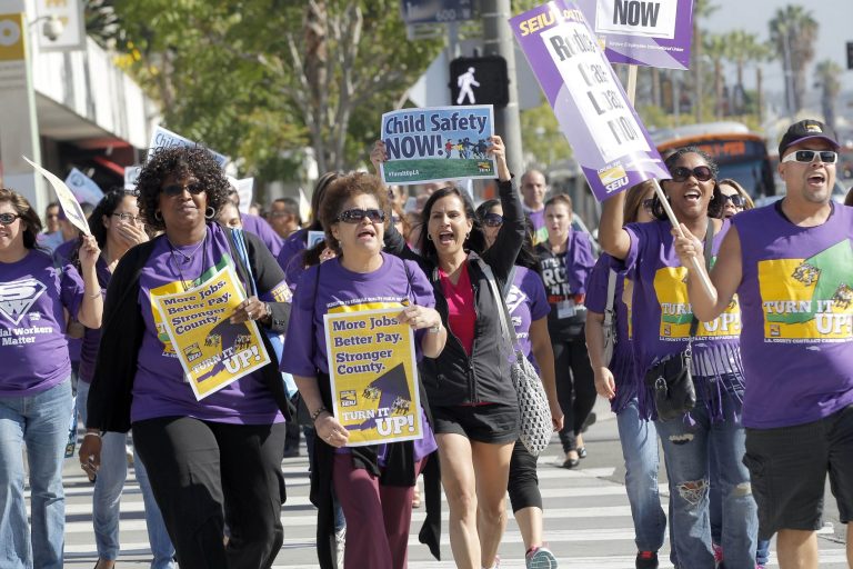 Service Employees International Union (SEIU) members protest for higher wages in downtown Los Angeles on Tuesday, Oct 1, 2013. Unionized Los Angeles County employees have walked off the job and taken to the streets to protest the collapse of contract negotiations.   (AP Photo/Nick Ut)