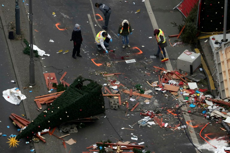Police officers inspect the crime scene in Berlin, Germany, the day after a truck ran into a crowded Christmas market and killed several people. (AP Photo/Markus Schreiber)