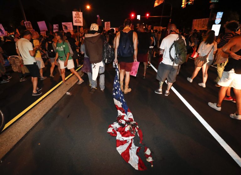 College students and others burned an American flag on American University's campus in Washington, D.C., on Wednesday afternoon in a move to denounce Donald Trump's victory in the presidential election a day earlier. (AP Photo/Alex Brandon)