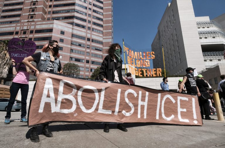 Protesters display a sign that reads "Abolish ICE" during a rally in front of the Immigration and Customs Enforcement facility in downtown Los Angeles on Monday, July 2, 2018. Protesters who were blocking the entrance to an Immigration and Customs Enforcement facility in downtown Los Angeles have been led away in handcuffs. A group of 17 protesters sat down in the street, blocking the entrance to the facility Monday morning. The protesters, including faith and community leaders, locked arms and chanted, "Shut down ICE!"