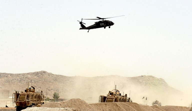 A U.S. military helicopter flies over the site of a suicide bomb that struck a NATO convoy in Kandahar south of Kabul on Wednesday. A suicide bomber struck a NATO convoy near the southern Afghan city of Kandahar on Wednesday, causing casualties, the U.S. military said. (AP Photo)