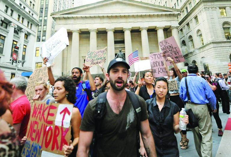 Hundreds of Occupy Wall Street protesters march past Federal Hall in New York.