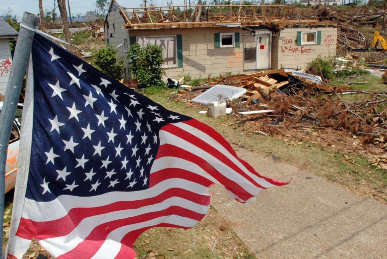 FILE - This May 23, 2011 file photo shows an American flag flying over the remains of a tornado-ravaged neighborhood in Tuscaloosa, Ala., a month after a killer storms in Alabama. Oklahoma and Kansas may have the reputation as tornado hotspots, but Florida and the rest of the Southeast are far more vulnerable to killer twisters, a new analysis shows. (AP Photo/Jay Reeves, File)