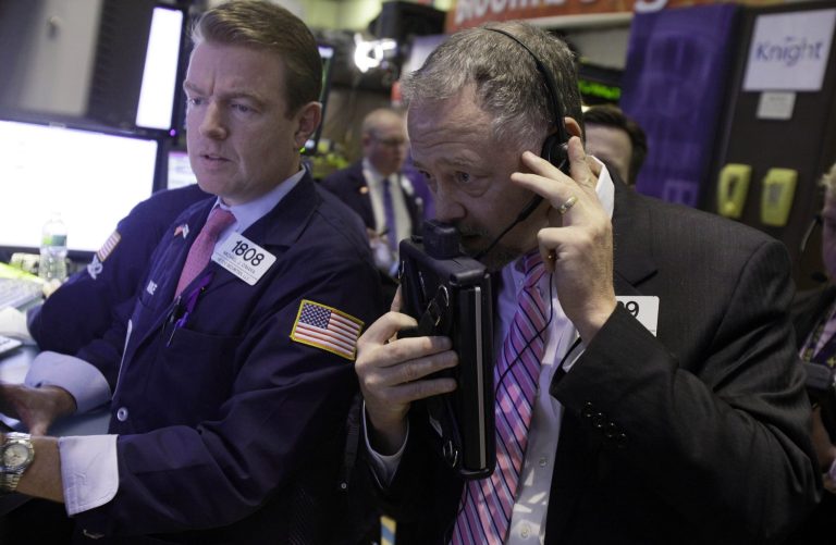   FILE - In this Thursday, Dec. 6, 2012, file photo, specialist Michael O'mara, left, and trader Robert Moran work on the floor of the New York Stock Exchange, in New York. Stock markets were in a holding pattern ahead of a U.S. jobs report later Friday Dec. 7, 2012 that is expected to reflect a downturn in hiring following a massive storm but could also show that the American economy is otherwise bouncing back. (AP Photo/Richard Drew, File)  