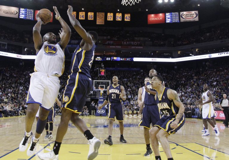   Golden State Warriors' Carl Landry (7) shoots next to Indiana Pacers' Ian Mahinmi, second from left, during the first half of an NBA basketball game in Oakland, Calif., Saturday, Dec. 1, 2012. (AP Photo/Marcio Jose Sanchez)  