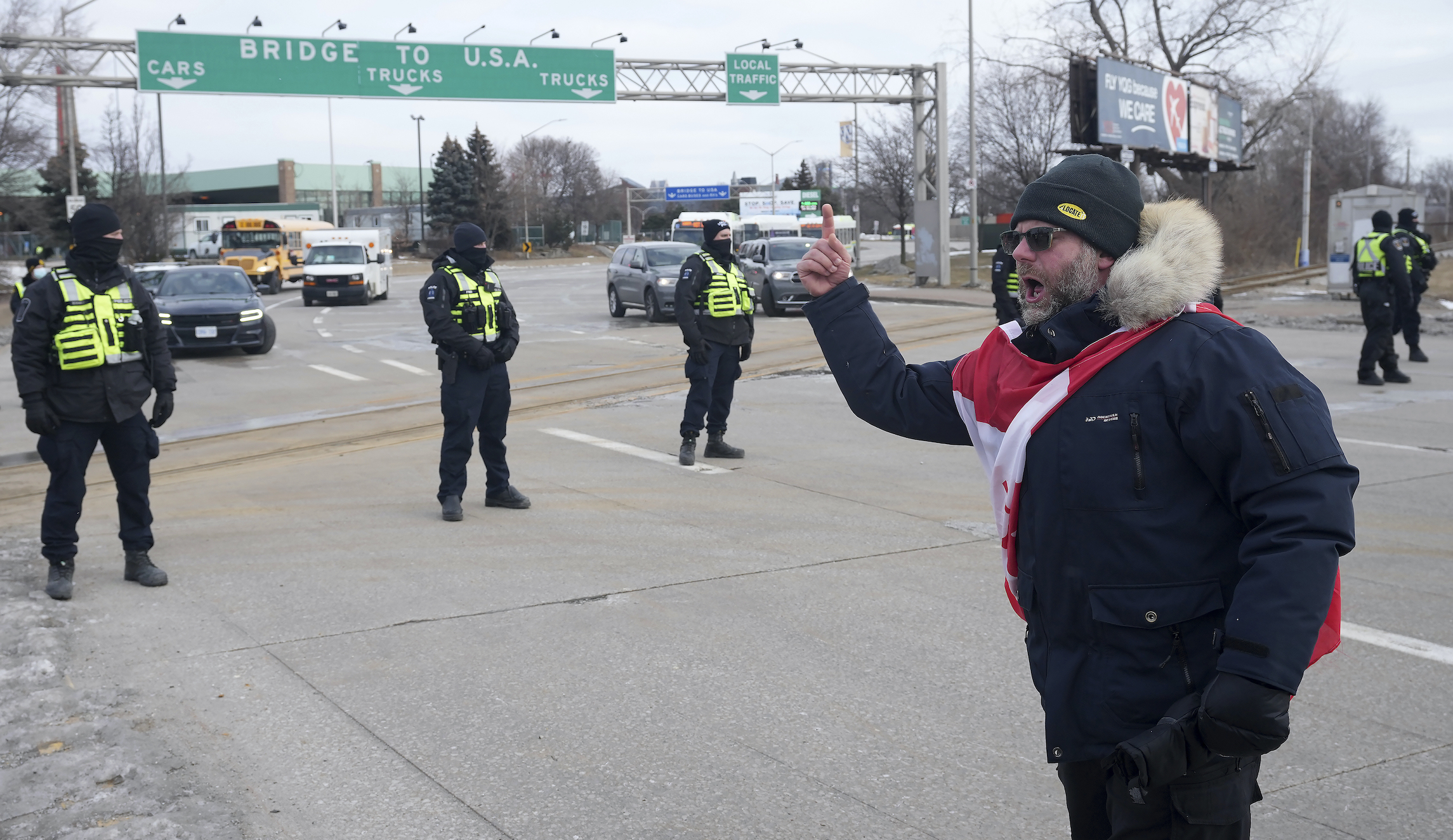 A protester yells at police officers as demonstrators prepare to leave in advance of police enforcing an injunction against their demonstration, which has blocked traffic across the Ambassador Bridge by protesters against COVID-19 restrictions, in Windsor, Ontario, on Saturday.