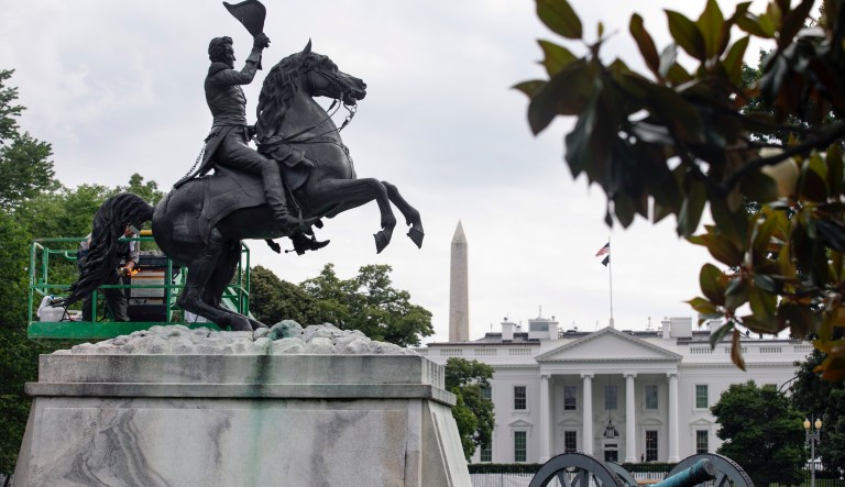 A National Park Service worker cleans a statue of President Andrew Jackson using fire, Thursday, June 11, 2020, near the White House in Washington, after protests over the death of George Floyd, a black man who was in police custody in Minneapolis. Floyd died after being restrained by Minneapolis police officers.