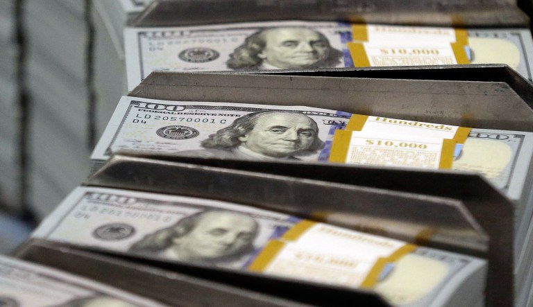 In this Sept. 24, 2013, file photo, just cut stacks of $100 bills make their way down the line at the Bureau of Engraving and Printing Western Currency Facility in Fort Worth, Texas.