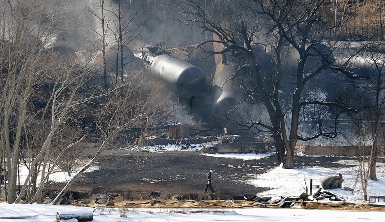 Crew members walk near the aftermath of a train derailment that occurred during a snowstorm, causing tankers to spill crude oil, explode and burn along the Kanawha River near Mount Carbon, W.Va.  