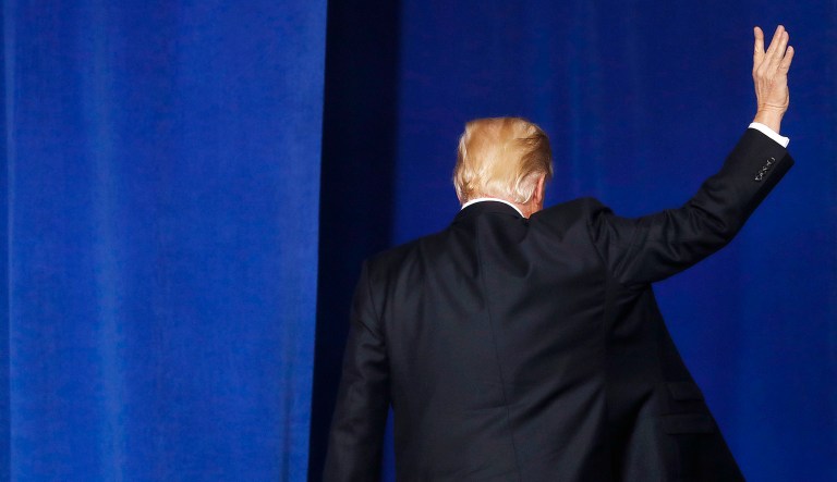 President Trump waves as he leaves the stage after speaking at an event.