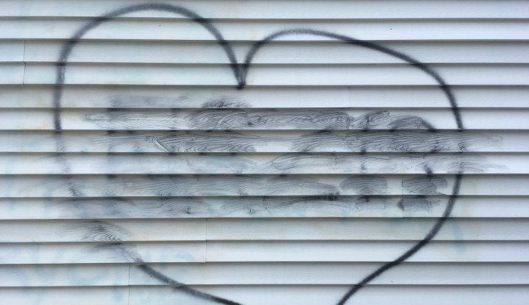 The word "NAZIS," smudged from a cleaning attempt, appears in the center of a heart symbol on the wall of a building, which houses the New Hampshire Republican Party, in Concord, N.H., Thursday Aug. 17, 2017. A party advisor is blaming "malcontents" for the vandalism.