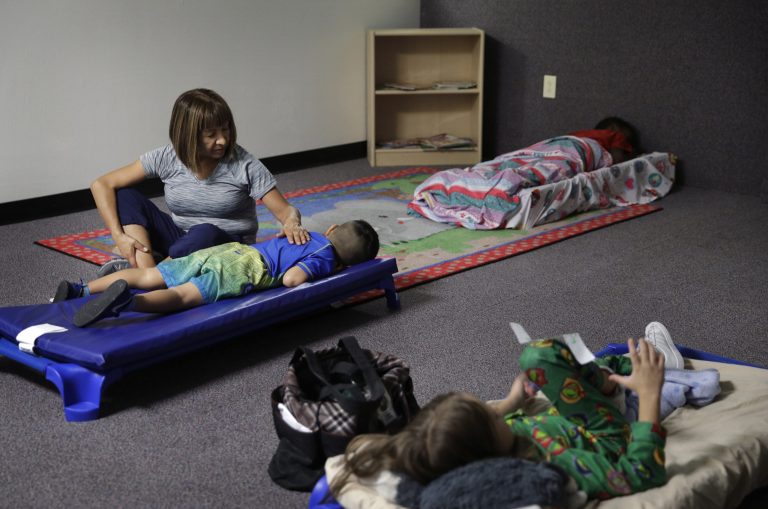 In this Sept. 14, 2017, photo, Hortencia Hansen helps a child go to sleep during bedtime at the McCarran International Child Development Center, a 24-hour daycare in Las Vegas. The FEC is being urged by lawyers for Hillary Rodham Clinton to let campaigns pay for the daycare of kids of candidates.