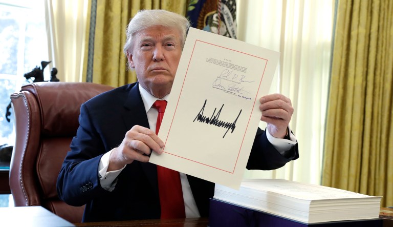 President Trump displays the $1.5 trillion tax overhaul package he had just signed.