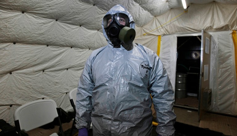 A marine officer of the Cape Ray, a ship equipped to neutralize Syrian chemicals, shows a chemical protection suit  to reporters, during a tour around the ship docked at the naval base of Rota used by the U.S, in Spainâs southwestern coast on Thursday, April 10, 2014. The American ship MV Cape Ray will collect and destroy mustard gas, raw materials for sarin nerve gas and tons of other highly toxic chemicals that form part of Syriaâs chemical weapons program. If Syria can remove all its ingredients for making poison gas and nerve agent from the country by the end of the month, an ambitious June 30 deadline for destroying the chemicals should be met, a spokesman for the world's chemical weapons watchdog said Thursday.