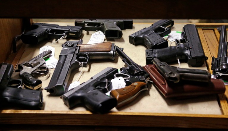 Pistols fill a case before an auction at Johnny's Auction House, where the company handles gun sales for a half dozen police departments and the Lewis County Sheriff's Office, in Rochester, Wash.