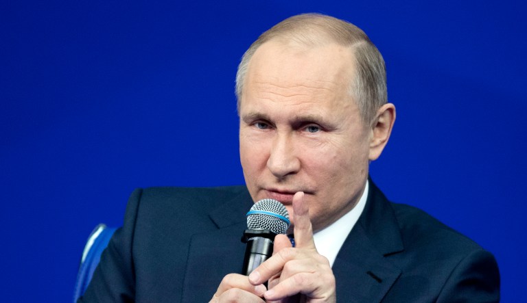 Russian President Vladimir Putin gestures while speaking.